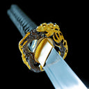 Close-up of gold-tone dragon alloy tsuba and blade collar