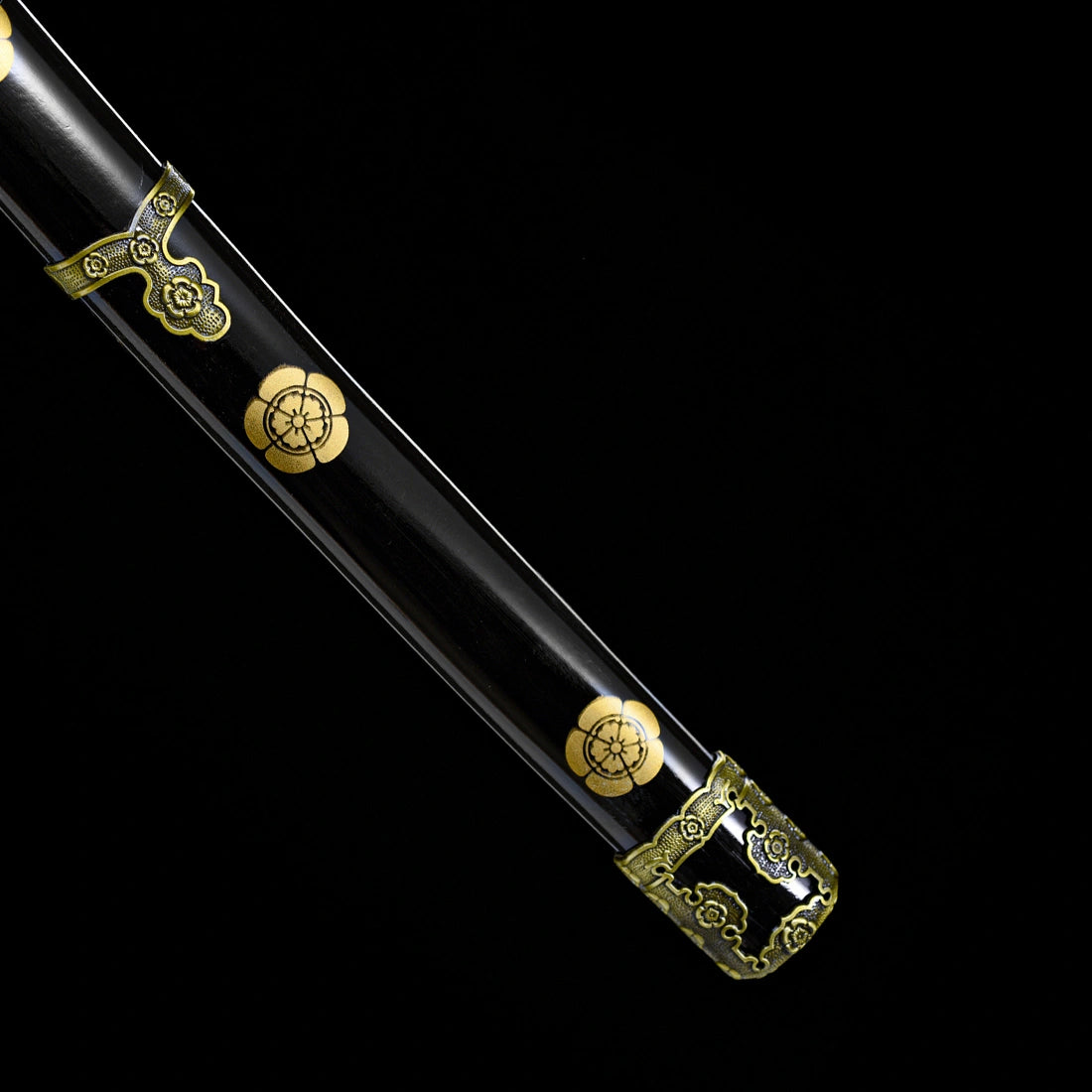 Black lacquered pear wood scabbard featuring golden sakura emblems and brass kojiri end cap