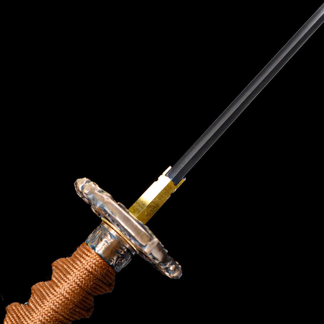 Angled close-up of gold-plated honeycomb Habaki collar, relief copper Tsuba, and brown cord wrapped handle on Dragonheir Tachi
