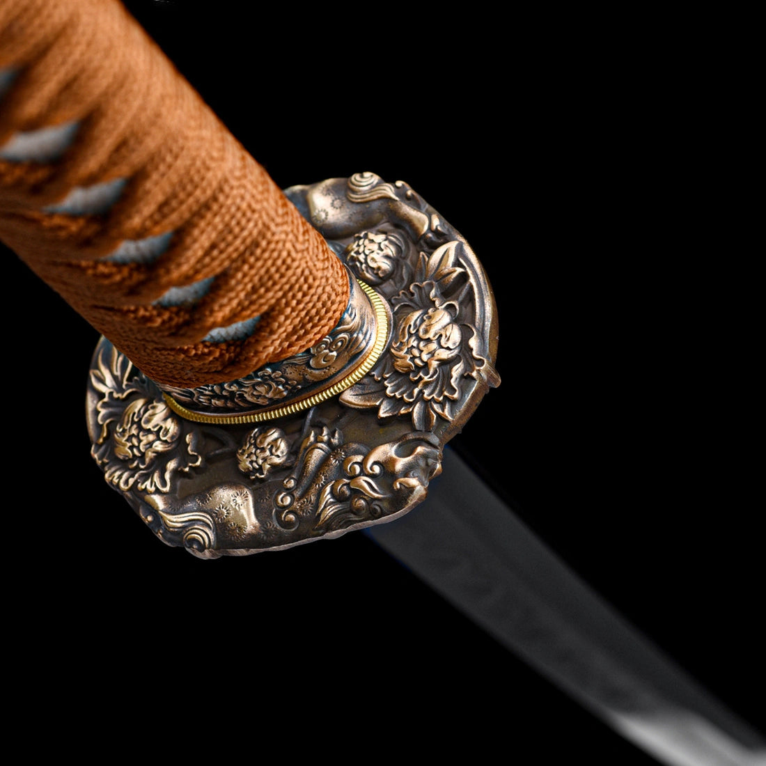 Detailed view of hand-carved pure copper floral Tsuba guard and brown cord wrapped handle on Dragonheir Tachi