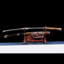 Dragonheir clay-tempered Damascus Tachi blade displayed horizontally above its gold-flecked lacquered Saya on dark stand