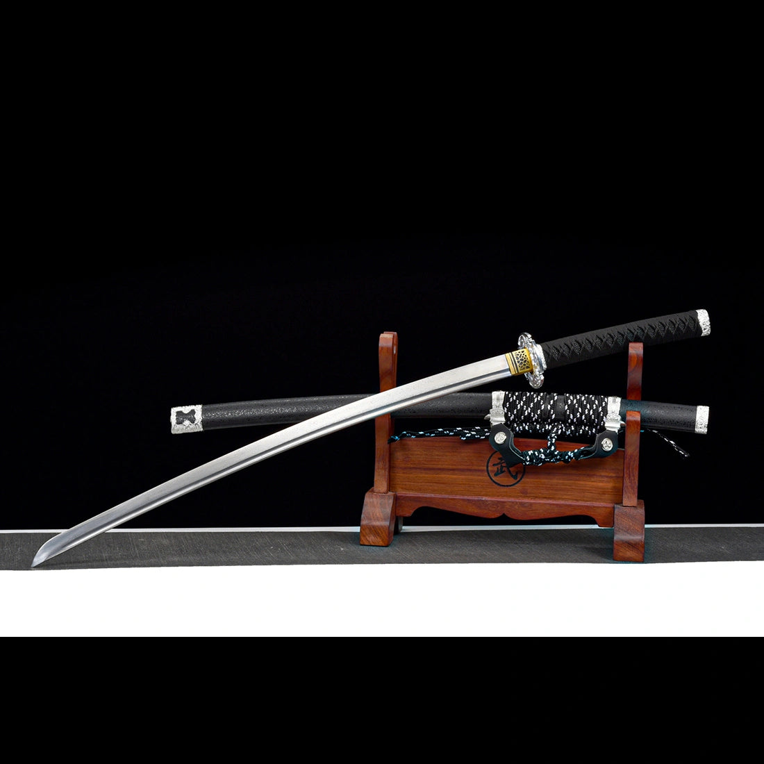 Unsheathed Oblivion Fang hand-forged Damascus steel tachi sword resting with scabbard on wooden display stand