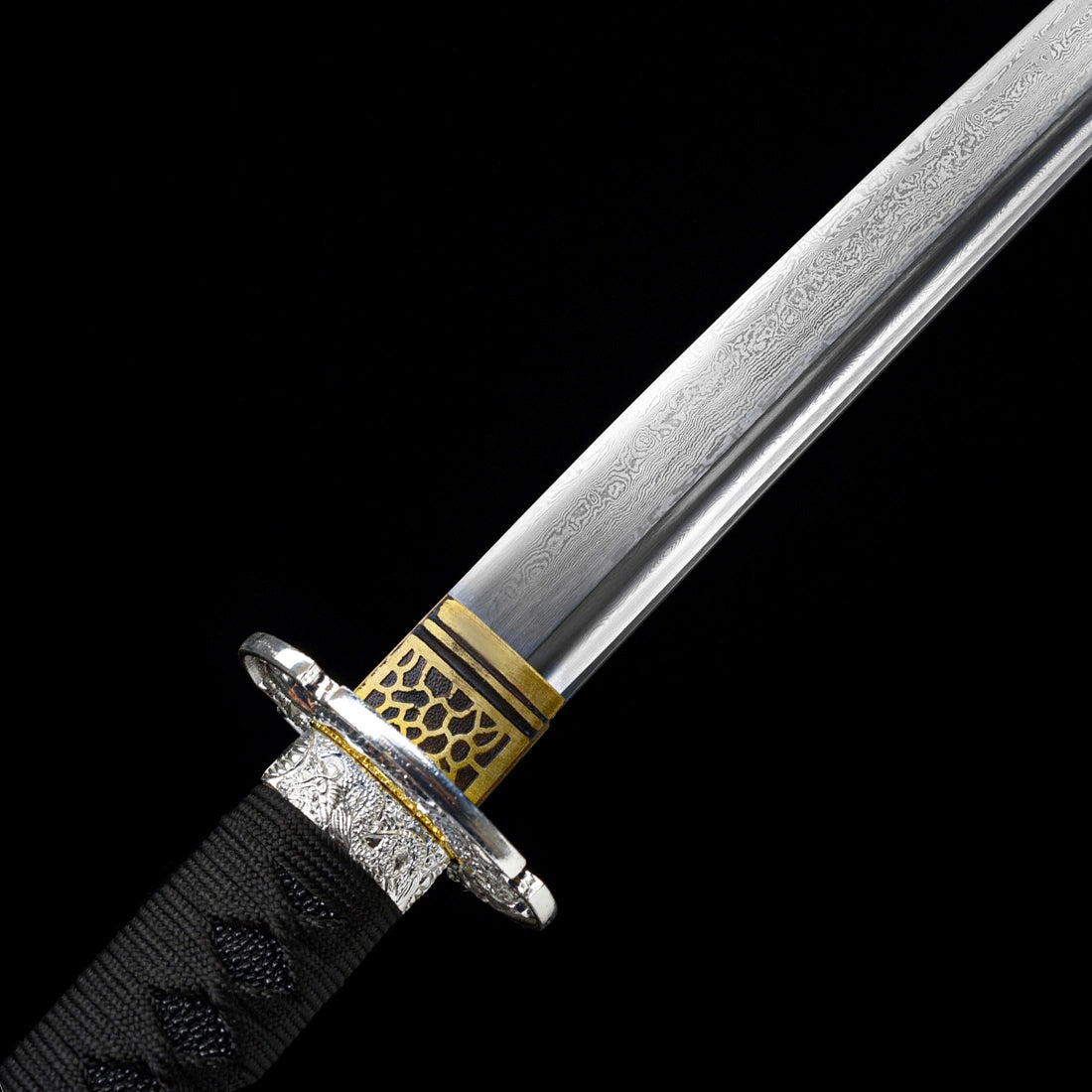 Close-up of hand-forged folded Damascus steel blade grain with honeycomb textured gold habaki on Oblivion Fang tachi