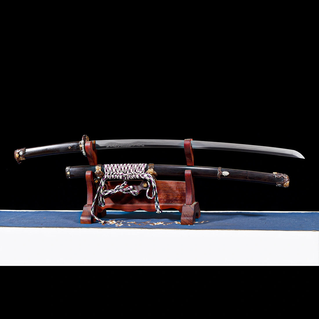 Tyrantclaw clay-tempered Wootz steel Tachi blade displayed unsheathed above its Brazilian ebony Saya on wooden stand