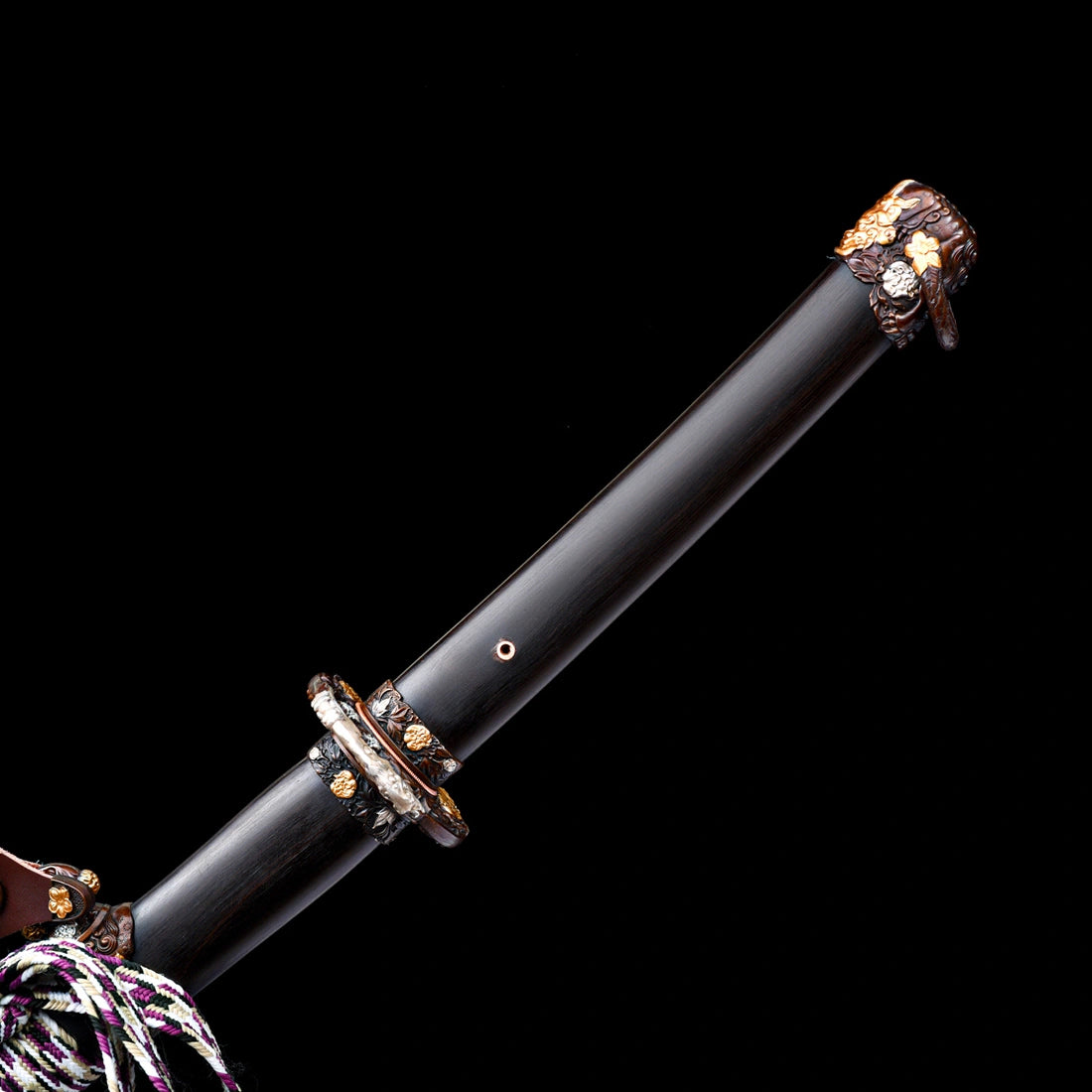 Smooth dark Brazilian ebony handle with hand-carved copper Kashira fitting featuring gold and silver animal inlays on Tyrantclaw Tachi