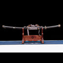 Tyrantclaw Tachi sword fully sheathed in Brazilian ebony scabbard displayed horizontally on wooden stand