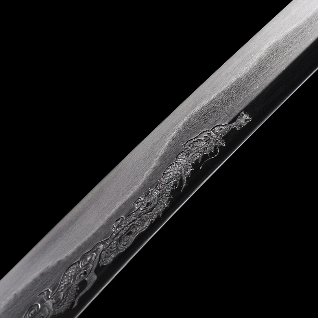 Close-up of single-sided hand-engraved Dragon Horimono on clay-tempered Wootz steel Tyrantclaw Tachi blade