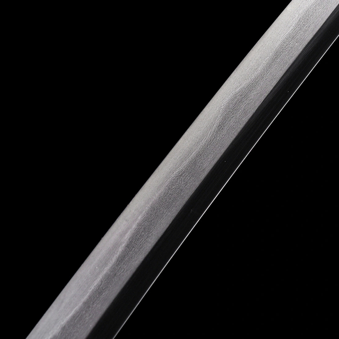 Detailed view of the organic wave micro-structure pattern on the clay-tempered Wootz steel Tyrantclaw Tachi blade