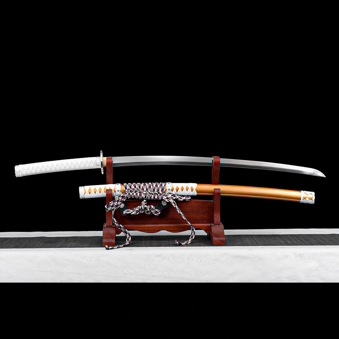 Unsheathed 104cm spring steel tachi sword resting on wooden display stand with orange scabbard
